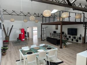 un soggiorno con tavolo, sedie e soppalco di Loft & Spa LE FAUBOURG SAINT MARTIN a Senlis