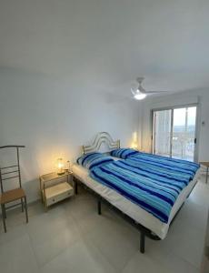 ein Schlafzimmer mit einem Bett, einem Stuhl und einem Fenster in der Unterkunft Manhattan apartment in Empuriabrava