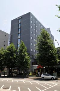 un'auto parcheggiata di fronte a un grande edificio di Hotel Route-Inn Tokyo Asagaya a Tokyo