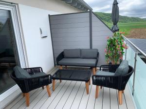 eine Terrasse mit 2 Stühlen und einer Couch auf einer Terrasse in der Unterkunft 2 Zimmer im Loft style über 2 Etagen in Kelheim