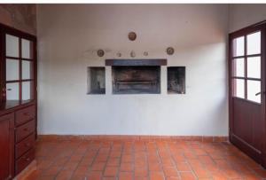 an empty room with a fireplace in a white wall at Casa Salta in Salta