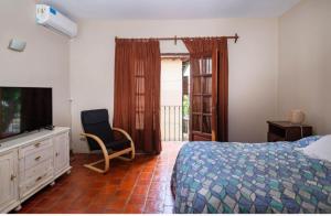 a bedroom with a bed and a television and a chair at Casa Salta in Salta