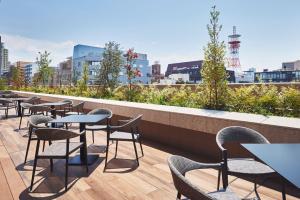 uma fila de mesas e cadeiras no telhado de um edifício em Citadines Harbour Front Yokohama em Yokohama