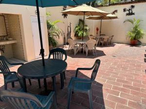 een patio met tafels en stoelen en een parasol bij Vallarta Sun Suites in Puerto Vallarta