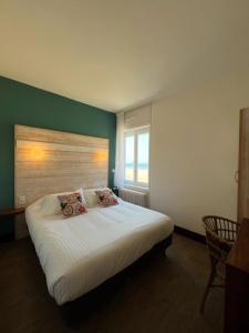 1 dormitorio con cama blanca y pared verde en Alba hotel, en Saint-Malo