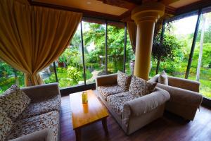 een woonkamer met banken, een tafel en ramen bij Bali Garden Beach Resort in Kuta