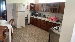 a kitchen with brown cabinets and a white refrigerator at Justice Seaview Apartment in Le Morne