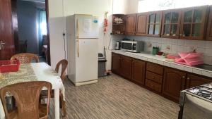 a kitchen with a white refrigerator and a table at Justice Seaview Apartment in Le Morne