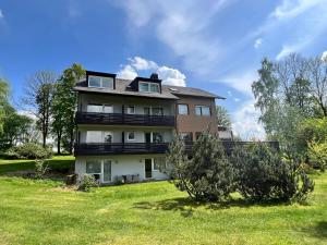 una casa grande con un césped verde delante de ella en Unsereins Hotel, en Bad Steben