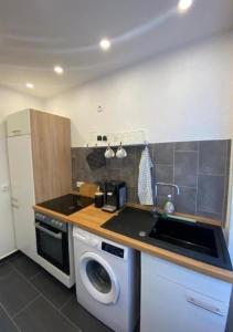 a kitchen with a sink and a washing machine at Moderne Wohnung in Neuwied City - fußläufig zum Rhein in Neuwied