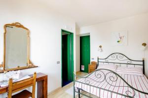 una camera con letto e specchio di Villa Pizzini Mottarone - Restaurant and rooms a Stresa