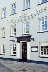 Kings Arms Hotel في بيسستر: مبنى ابيض امامه باب