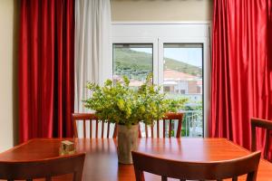 uma sala de jantar com uma mesa e cortinas vermelhas em Elia Villa Thassos em Prinos