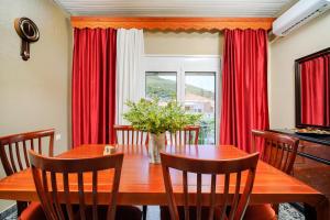 uma sala de jantar com uma mesa e cortinas vermelhas em Elia Villa Thassos em Prinos