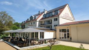 un hotel con tavoli e ombrelloni all'esterno di Hotel Stempferhof a Gössweinstein