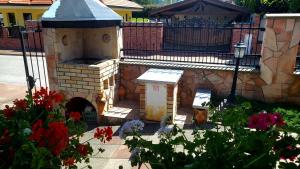 a brick oven in a garden with flowers at Selfness Rožňava in Rožňava