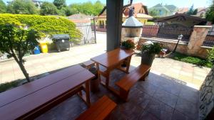 a patio with two benches and a table with flowers at Selfness Rožňava in Rožňava