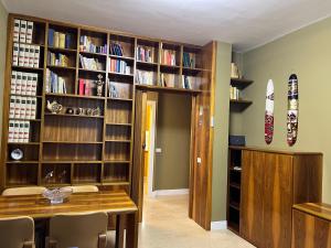 une salle à manger avec une table et une étagère à livres dans l'établissement Rosanna House - Vedano Al Lambro, à Monza