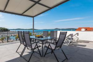 einen Tisch und Stühle auf einer Terrasse mit Meerblick in der Unterkunft Apartment and Rooms Dalmatiko in Vodice