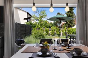 uma sala de jantar com uma mesa e um guarda-chuva em Bungalow für 2 - Parkplatz - Küche - Terrasse em Speyer