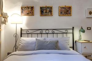 um quarto com uma cama com três fotografias na parede em Florence Holiday Homes Ponte Vecchio em Florença