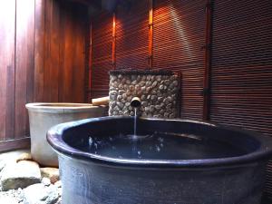 una grande vasca da bagno con fontana di Ryokan Tanabe a Takayama