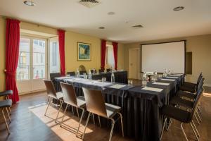 uma sala de conferências com uma mesa longa e cadeiras em Vila Gale Collection Palácio dos Arcos em Oeiras