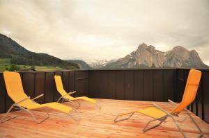 due sedie su una terrazza con montagne sullo sfondo di Kastelart - Karbon a Castelrotto