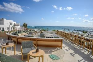 a patio with chairs and tables and the ocean at Creta Maris Resort in Hersonissos