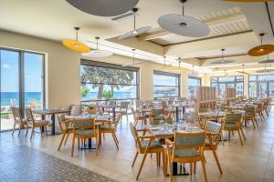 a dining room with tables and chairs and the ocean at Creta Maris Resort in Hersonissos