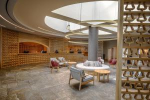 a lobby with a fireplace and tables and chairs at Creta Maris Resort in Hersonissos