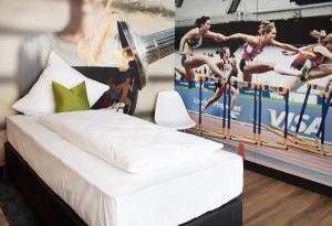 - une chambre avec un lit et une affiche murale dans l'établissement ZWI Hotel by WMM Hotels, à Zwickau