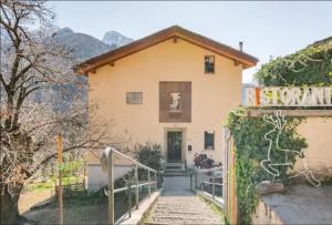 uma pequena casa com uma escada que leva até ela em Foresteria B&B Vecchiascuola Pianazzola em Chiavenna