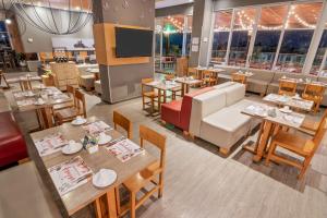 a restaurant with tables and chairs and a couch at GHL Style Yopal in Yopal