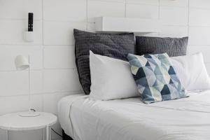 um quarto com uma cama com almofadas e uma mesa em Moody's Beach Apartment em Blairgowrie