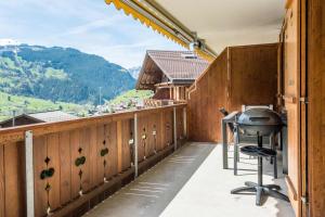 a balcony with a grill and mountains in the background at Apartment Dolce Vita - GRIWA RENT AG in Grindelwald