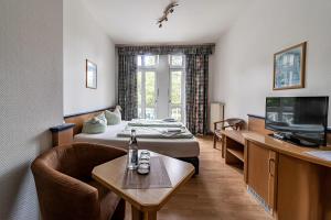 a hotel room with a bed and a tv at Appartement-Hotel-Anlage Tannenpark in Tanne