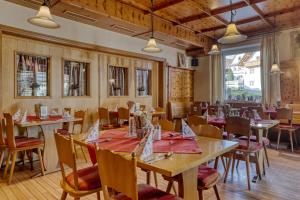 una sala da pranzo con tavoli e sedie in legno di Hotel Bayerischer Hof a Bodenmais