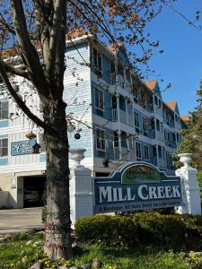 een gebouw met een molenkreekbord voor een boom bij Mill Creek Hotel in Lake Geneva