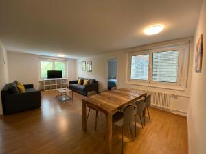 - un salon avec une table en bois et un canapé dans l'établissement Galaxy Apartments Lucerne, à Lucerne