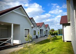 une rangée de maisons blanches aux toits rouges dans l'établissement Domki Letniskowe Ratownik, à Sarbinowo