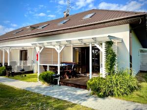 une maison avec une terrasse et un toit dans l'établissement Domki Letniskowe Ratownik, à Sarbinowo