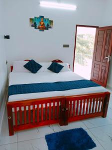 a bedroom with a red and blue bed with a window at ENOCEAN HOMESTAY in Cherai Beach