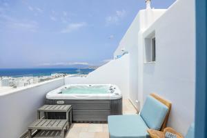 een balkon met een hot tub en een stoel bij Ibiscus Boutique in Mykonos-stad