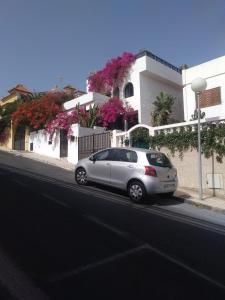 ein silbernes Auto, das am Straßenrand geparkt ist in der Unterkunft VV Las Buganvillas MASPALOMAS - Cocina y habitaciones con baños privados in Maspalomas