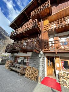 un edificio con balcones de madera y una pila de troncos en B&B Gressoney, en Gressoney-la-Trinité