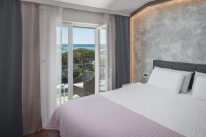 1 dormitorio con cama y ventana grande en Hotel Tomi, en Portorož