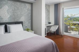 1 dormitorio con cama, escritorio y ventana en Hotel Tomi, en Portorož