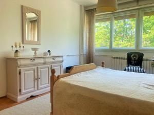 a bedroom with a bed and a dresser and a window at BAJKA in Čačak