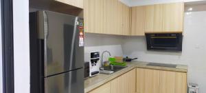 Miri Sunsky Condominium Homestay 3 Rooms & 6 Guest في ميري: مطبخ مع ثلاجة ستيل ستانلس وميكروويف